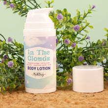 Load image into Gallery viewer, Body lotion bottle labeled &#39;In The Clouds&#39; with a plant and candle in the background