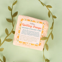 Load image into Gallery viewer, Two pink shower steamer cubes with labels on a light green background with leaf patterns.