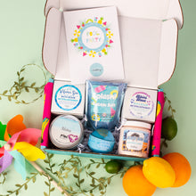 Load image into Gallery viewer, Box of bath products with colorful packaging on a light green background