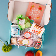 Load image into Gallery viewer, Open box containing various items with a &#39;Hello Summer&#39; card on a blue background