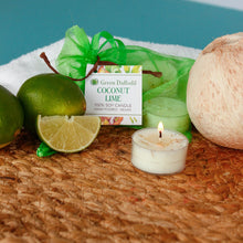 Load image into Gallery viewer, Coconut lime candle with limes, a coconut, and a green ribbon on a textured surface.