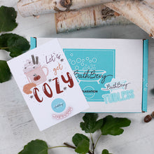 Load image into Gallery viewer, Bath and body product packaging with &#39;Let&#39;s get cozy&#39; card on a wooden surface with leaves.