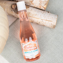 Load image into Gallery viewer, Bottle of White Pumpkin bubble bath on a textured surface with birch logs in the background